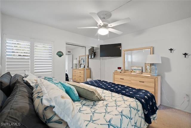 carpeted bedroom featuring ceiling fan and a closet