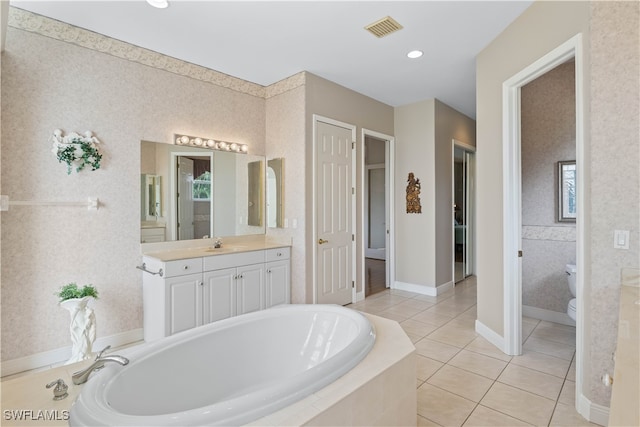 bathroom with plenty of natural light, vanity, and a relaxing tiled tub