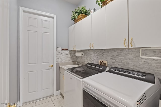 washroom with light tile patterned floors, cabinets, sink, and washing machine and dryer