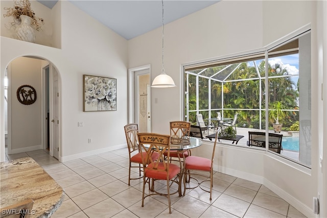 tiled dining room with a towering ceiling