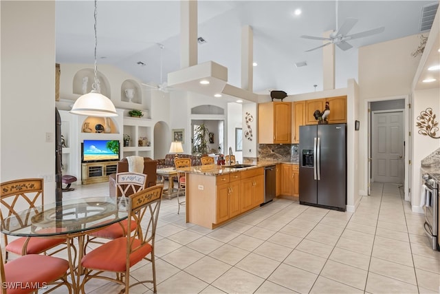 kitchen with appliances with stainless steel finishes, high vaulted ceiling, kitchen peninsula, ceiling fan, and sink