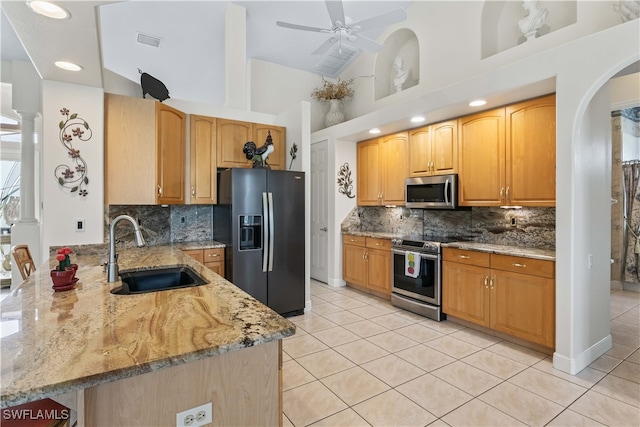 kitchen featuring sink, high vaulted ceiling, stainless steel appliances, light stone countertops, and ceiling fan