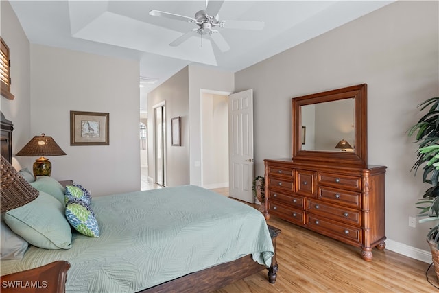 bedroom with light hardwood / wood-style flooring, connected bathroom, and ceiling fan