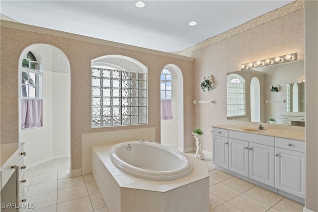 bathroom featuring tile patterned floors, tiled bath, and vanity