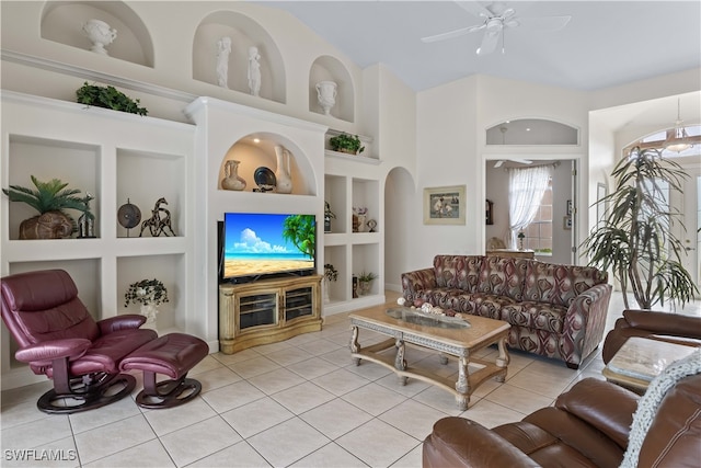 living room featuring built in shelves, light tile patterned floors, and ceiling fan