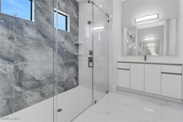 bathroom featuring vanity and a shower with door