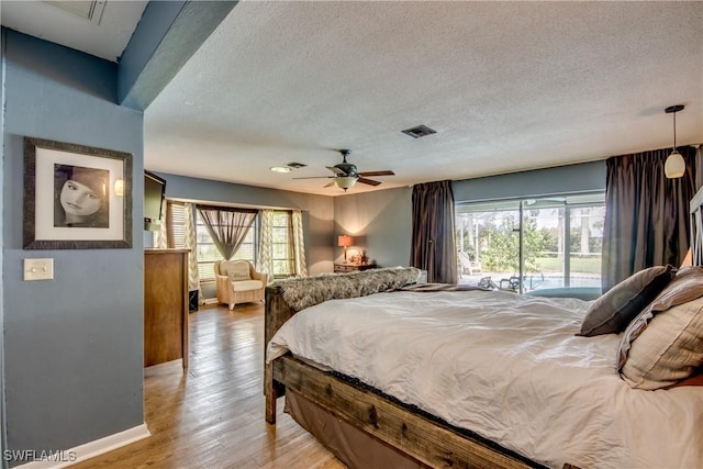 bedroom with a textured ceiling, access to outside, light hardwood / wood-style flooring, and ceiling fan