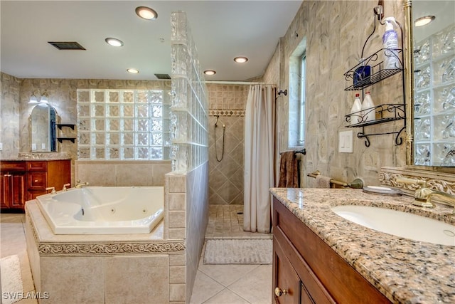 bathroom with tile patterned floors, vanity, separate shower and tub, and tile walls