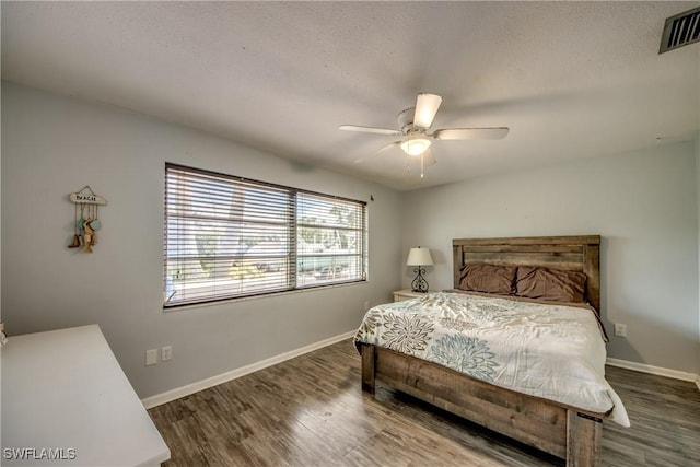 bedroom with ceiling fan and dark wood-type flooring