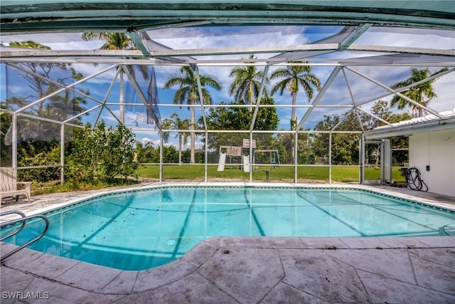 view of swimming pool featuring glass enclosure and a patio area