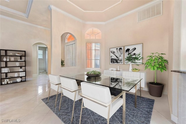 tiled dining room featuring arched walkways, visible vents, baseboards, and ornamental molding