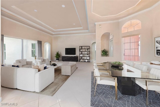 living room with ornamental molding, a tray ceiling, arched walkways, and tile patterned flooring