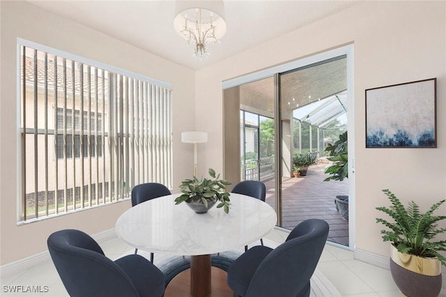 dining area with an inviting chandelier, baseboards, plenty of natural light, and light tile patterned floors