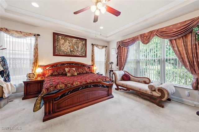 carpeted bedroom featuring a tray ceiling, ornamental molding, and recessed lighting