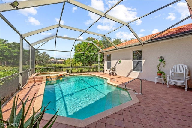 view of swimming pool featuring an in ground hot tub, a patio, and a lanai