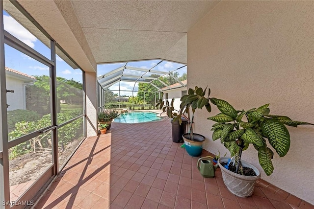view of patio with a lanai and a pool with connected hot tub