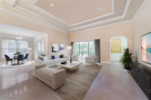 tiled living room with an inviting chandelier, a tray ceiling, a high ceiling, and crown molding