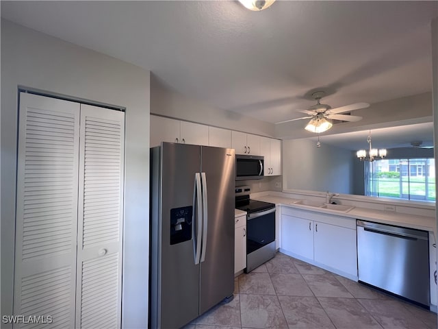 kitchen featuring sink, ceiling fan with notable chandelier, white cabinetry, stainless steel appliances, and decorative light fixtures