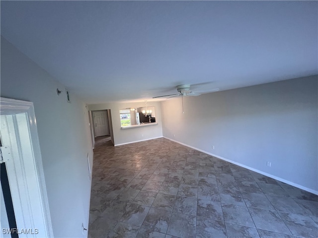 unfurnished living room featuring ceiling fan with notable chandelier