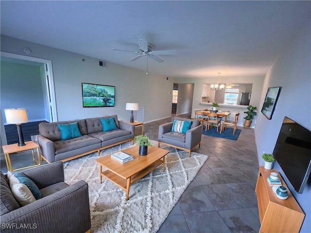 living room featuring ceiling fan with notable chandelier