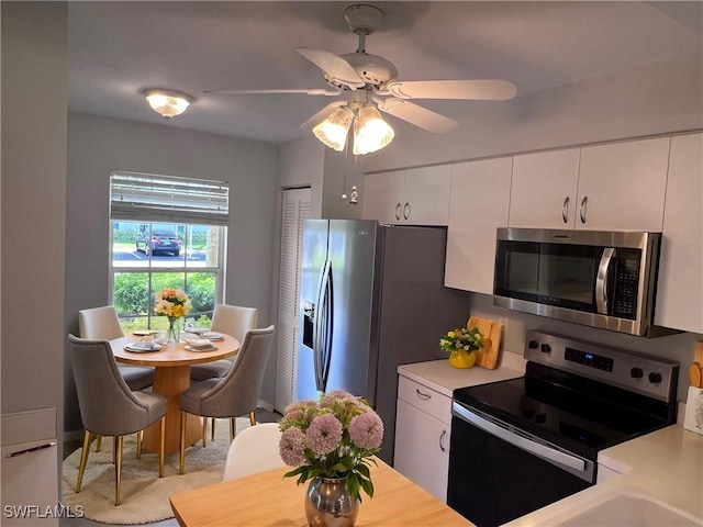 kitchen featuring ceiling fan, white cabinetry, and stainless steel appliances