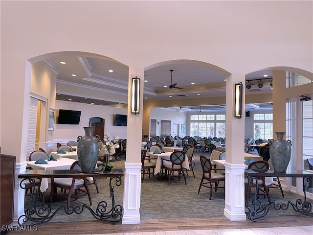 dining room featuring decorative columns, crown molding, wood-type flooring, and ceiling fan