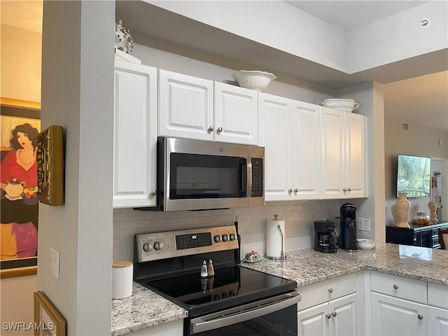 kitchen with tasteful backsplash, appliances with stainless steel finishes, and white cabinets