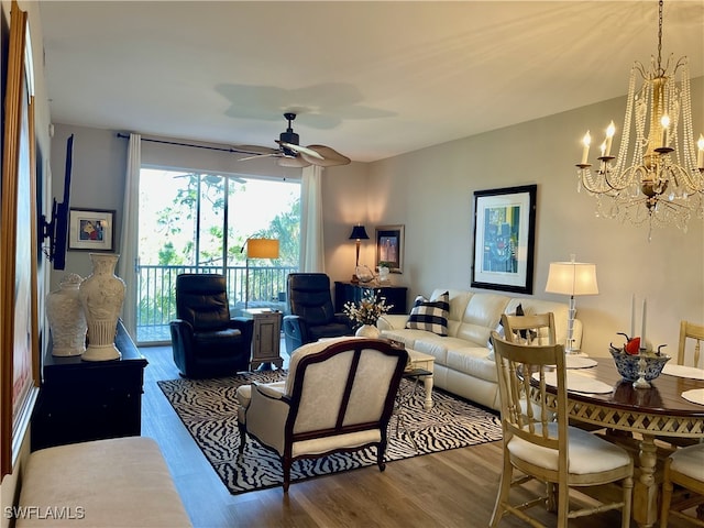 living room featuring ceiling fan with notable chandelier and hardwood / wood-style floors