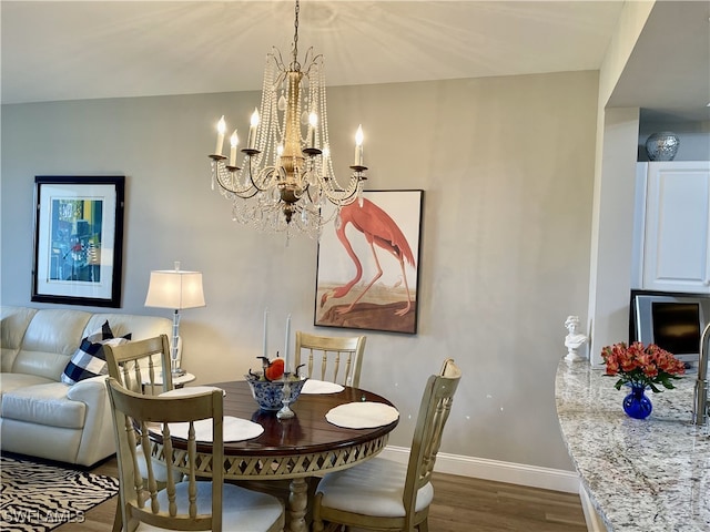 dining room featuring dark hardwood / wood-style flooring and an inviting chandelier