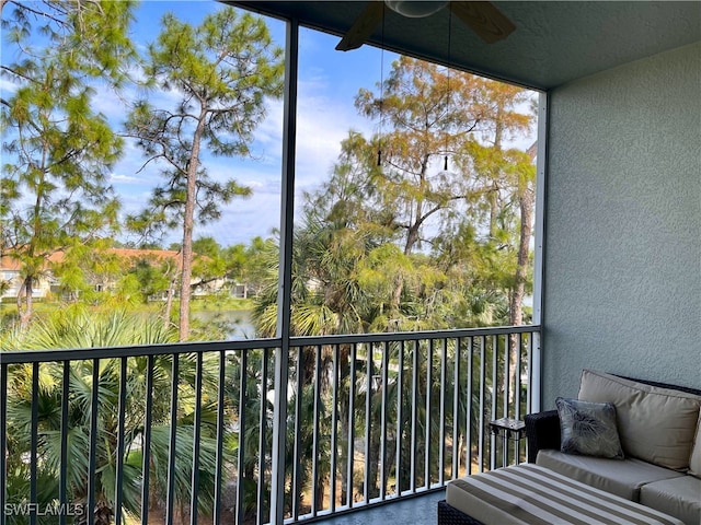 balcony featuring a water view and ceiling fan