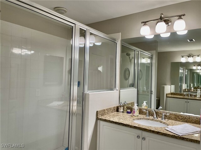 bathroom with vanity, toilet, and a shower with shower door