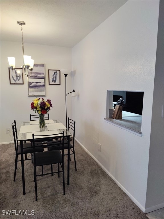 dining room with a chandelier and dark carpet