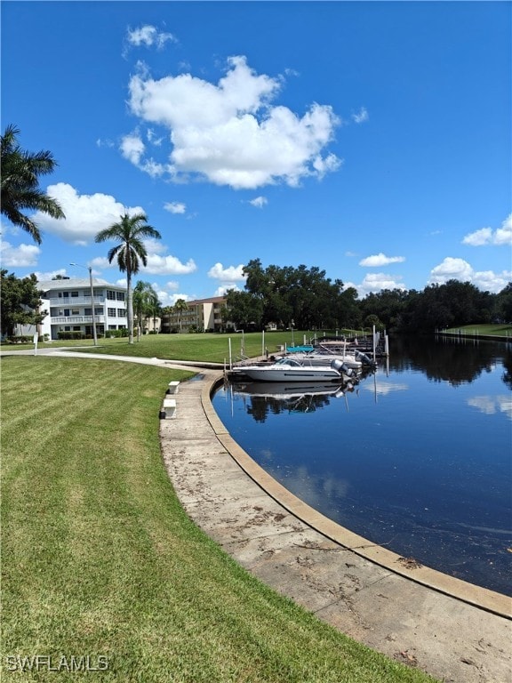 view of pool featuring a dock, a water view, and a lawn