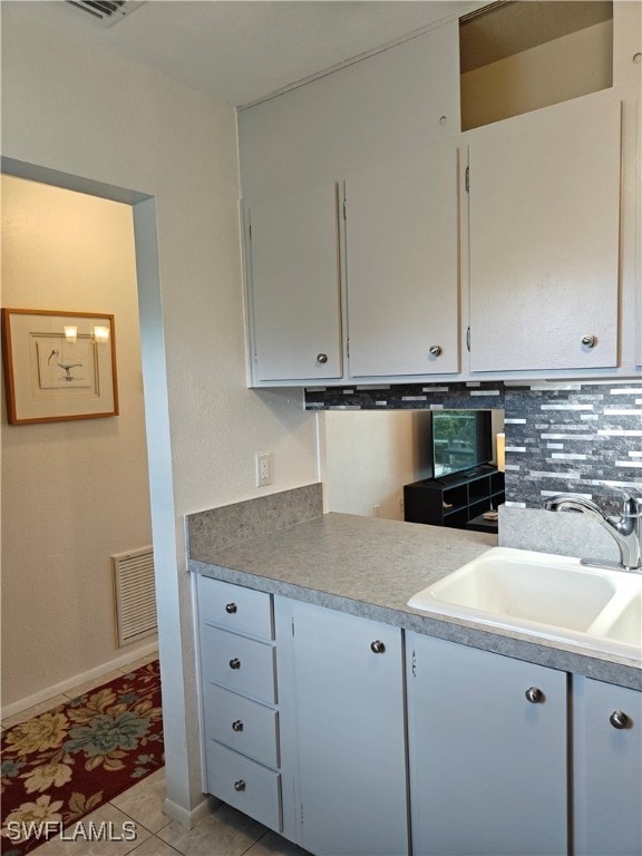 kitchen with sink, light tile patterned flooring, and backsplash