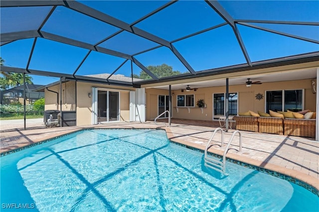 view of swimming pool with an outdoor living space, glass enclosure, a patio area, and ceiling fan