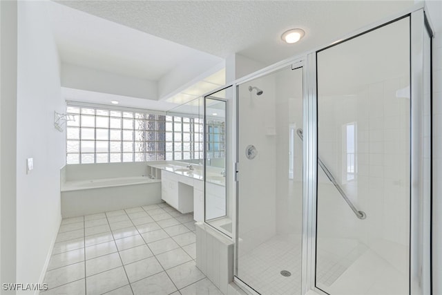 bathroom featuring vanity, separate shower and tub, a textured ceiling, and tile patterned floors