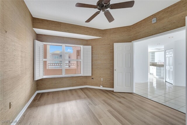 empty room with ceiling fan and light hardwood / wood-style floors