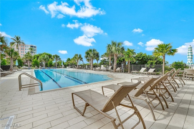 pool with a patio area and fence