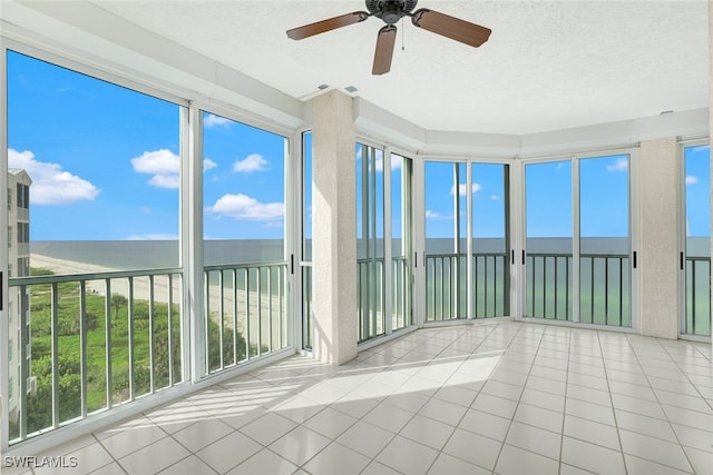 unfurnished sunroom featuring a water view and ceiling fan