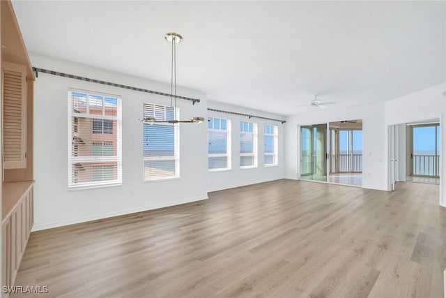 unfurnished living room with a ceiling fan, light wood-type flooring, and baseboards