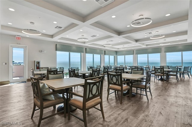dining room with a water view, wood finished floors, visible vents, and coffered ceiling