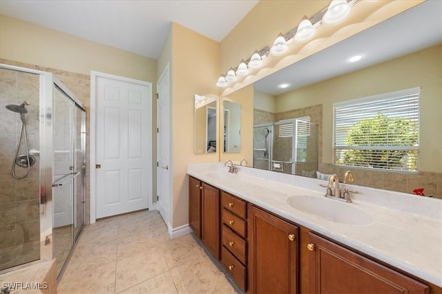 bathroom featuring tile patterned flooring, vanity, and a shower with door