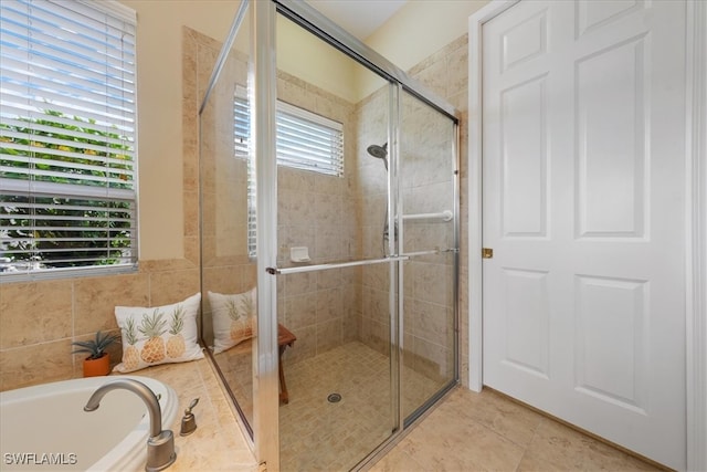 bathroom with shower with separate bathtub and tile patterned floors