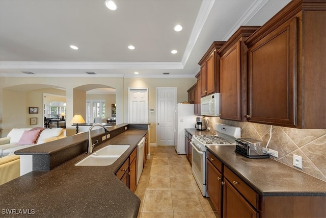 kitchen featuring white appliances, crown molding, sink, light tile patterned floors, and tasteful backsplash