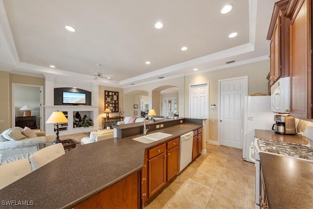 kitchen featuring ceiling fan, sink, white appliances, a tray ceiling, and ornamental molding