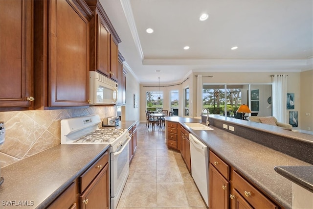 kitchen featuring white appliances, backsplash, ornamental molding, and sink