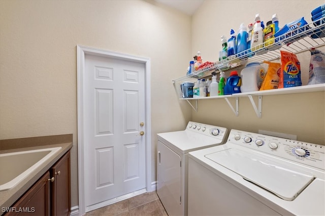 laundry area with sink, light tile patterned floors, cabinets, and independent washer and dryer