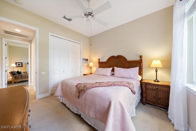 bedroom featuring ceiling fan, light colored carpet, and a closet