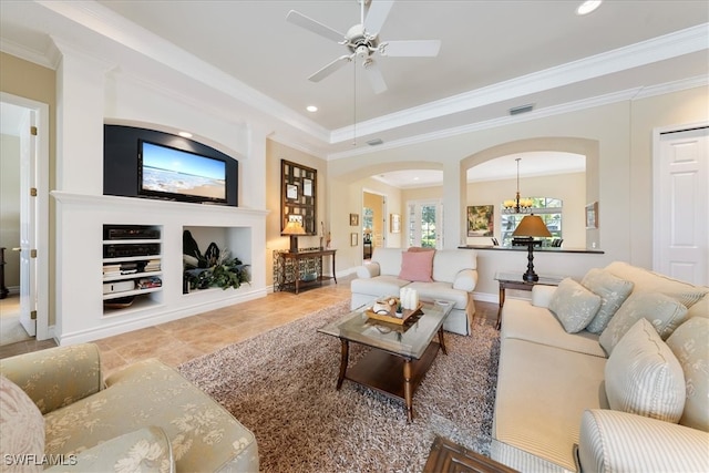 tiled living room featuring built in features, ceiling fan with notable chandelier, and ornamental molding