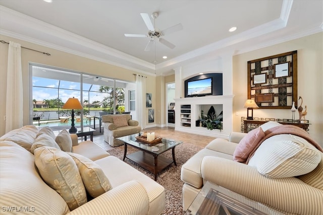 tiled living room with ceiling fan, crown molding, and a tray ceiling